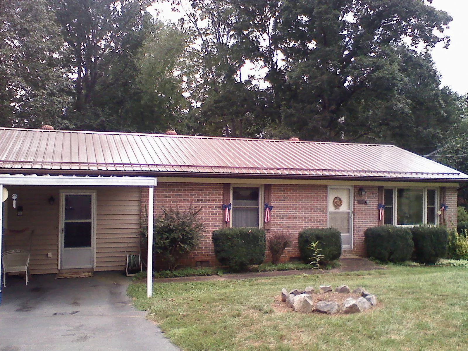 Bronze metal roof and carport on a brick ranch home — Roof Repair work by our crew in Dickey